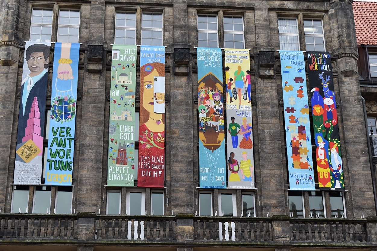 Gestaltet wurden die sieben Meter langen Friedensbanner am Rathaus von Schülerinnen und Schülern, die an dem von Aktion © initiierten Kunstprojekt teilgenommen haben.